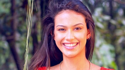 Stunning Latina woman tosses her hair back as she smiles with delight in slow motion