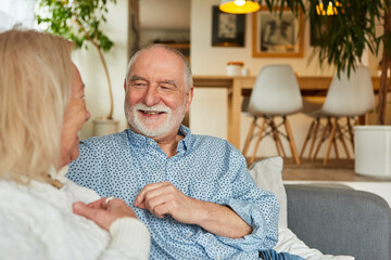 Glückliche Rentner beim entspannten Gespräch zu Hause