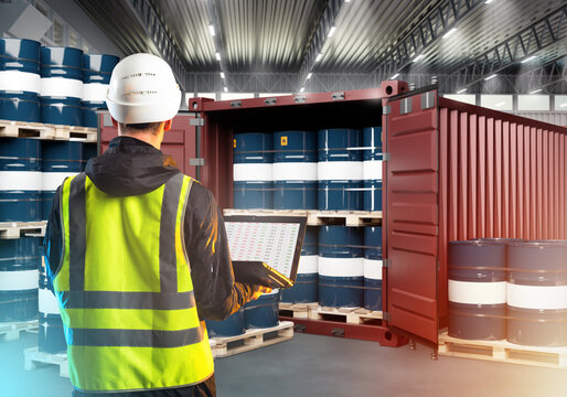 Warehouse Supervisor. Inspector is man with his back to camera. Guy with laptop looks at barrels. Sea container with barrels inside warehouse. Man storekeeper controls delivery. Audit, revision