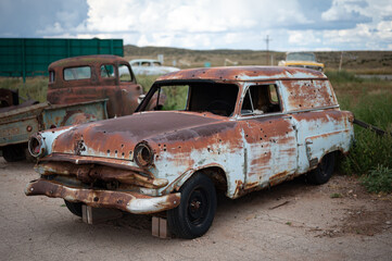 Old abandoned Ford Courier Sedan Delivery, it is rusty and with bullet holes