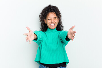 Young african american woman isolated feels confident giving a hug to the camera.