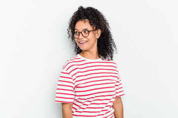 Young african american woman isolated looks aside smiling, cheerful and pleasant.