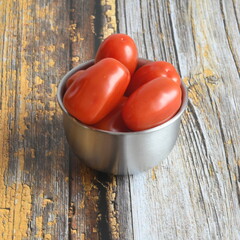 Cherry Tomatoes in bowl on wooden table