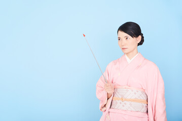 指し棒を持つ着物を着た女性