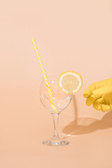 hand in a yellow glove holds a glass of water with lemon. Bar design concept