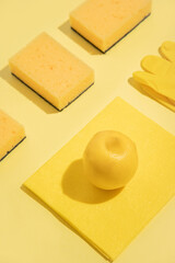 Lemon freshness. Cleaning products foam sponge, cloth rag, rubber gloves. Concept idea. yellow background.