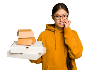 Young student asian woman holding a takeaway food isolated biting fingernails, nervous and very anxious.