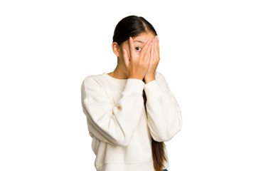 Young Asian woman isolated blink through fingers frightened and nervous.