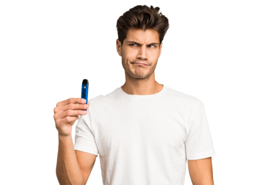 Young caucasian man holding an electronic cigarette isolated confused, feels doubtful and unsure.