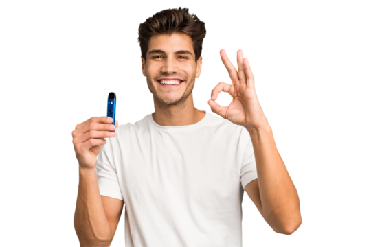 Young caucasian man holding an electronic cigarette isolated cheerful and confident showing ok gesture.
