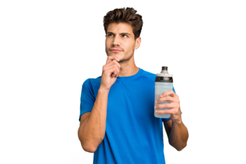 Young sport caucasian man holding a bottle of water isolated looking sideways with doubtful and skeptical expression.