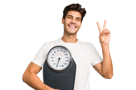 Young caucasian man holding a scale isolated joyful and carefree showing a peace symbol with fingers.
