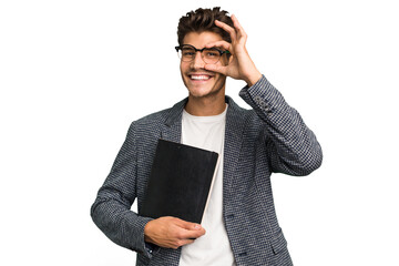 Young teacher caucasian man holding a book isolated excited keeping ok gesture on eye.