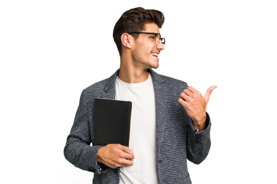 Young teacher caucasian man holding a book isolated points with thumb finger away, laughing and carefree.