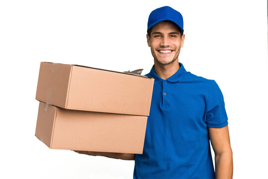 Young delivery caucasian man holding boxes isolated happy, smiling and cheerful.