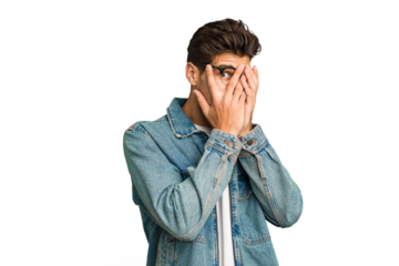 Young caucasian handsome man isolated blink through fingers frightened and nervous.