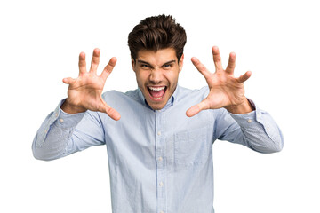 Young caucasian handsome man isolated showing claws imitating a cat, aggressive gesture.