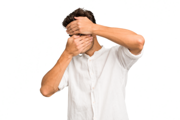 Young caucasian handsome man isolated blink at the camera through fingers, embarrassed covering face.