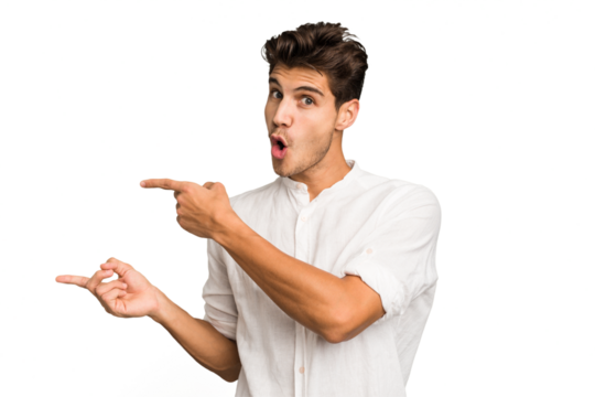 Young caucasian handsome man isolated pointing with forefingers to a copy space, expressing excitement and desire. - Powered by Adobe