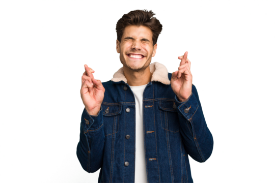 Young caucasian handsome man isolated crossing fingers for having luck