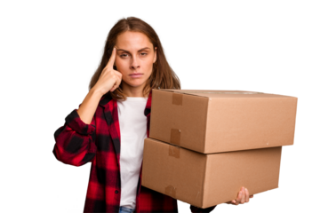 Young caucasian woman moving while picking up a box full of things isolated pointing temple with finger, thinking, focused on a task.