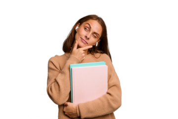 Young student woman holding a books isolated looking sideways with doubtful and skeptical expression.