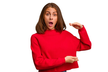 Young caucasian woman isolated holding something with both hands, product presentation.