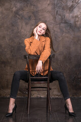 Young stylish model in a suede orange jacket