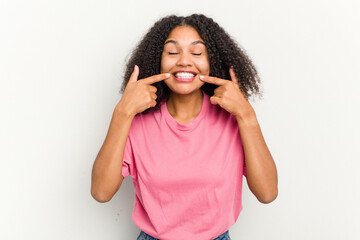 Fototapeta premium Young african american woman isolated on white background smiles, pointing fingers at mouth.