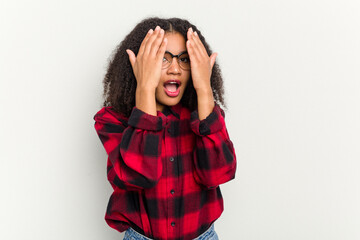 Young african american woman isolated on white background having fun covering half of face with palm.