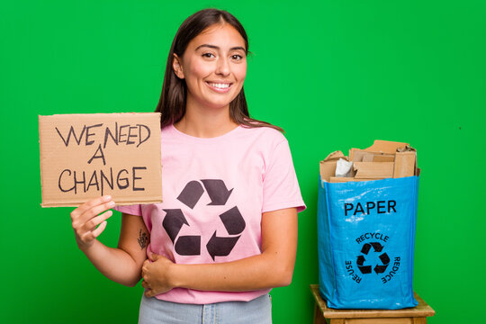 Young caucasian recycler woman holding a we need a change placard isolated laughing and having fun.