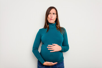 Pregnant caucasian woman isolated on white background confused, feels doubtful and unsure.