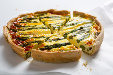 Close up of sliced quiche savory asparagus pie food on light surface