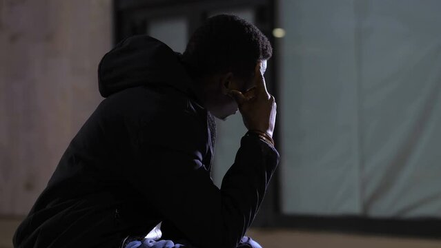 despair, anguish - sad depressed black man in the city at night thinking