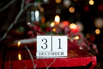 December 31 calendar on the background of a Christmas tree with decor and candles. happy New Year