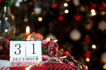 calendar with the date December 31 on the background of candles and Christmas decor in red