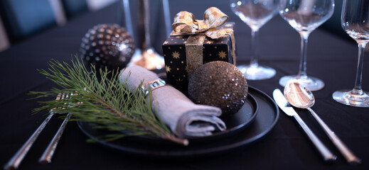Atmospheric table decoration for a christmas or new year dinner. Festive place setting in modern...