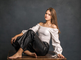young teenage girl on dark studio wall background