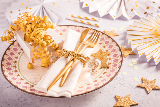 Festive place setting for Christmas and New Year with paper  fans in golden tone