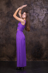 Portrait of a young beautiful brunette girl in purple pantsuit