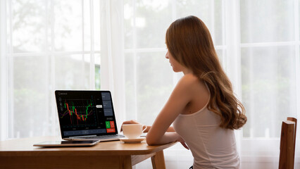 Young business woman using computer trading stock market exchange online. Trader analyzing data and investment concept.