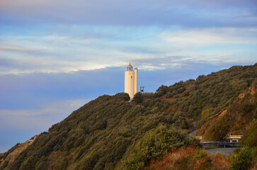 Faro de Gorliz al atardecer rodeado de vegetación 