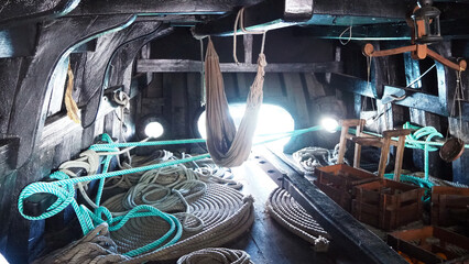 Ship interior with a coil of thick rope, hammock