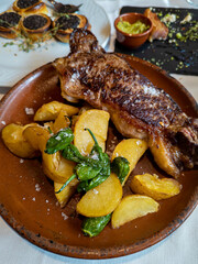 Typical Spanish dish called beef entrecote with padrón peppers and baked potatoes
