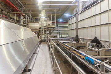 Big fryer machine and potato conveyor line in a chips factory.