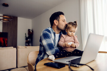 Dad is kissing his beloved daughter on a break from remote work.