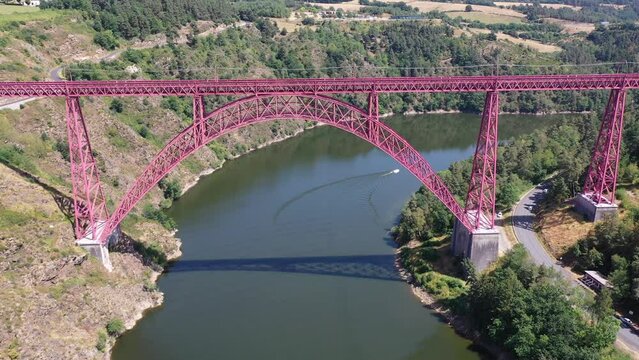 Scenic drone view of parabolic arched framework of railway bridge Viaduc de Garabit across river Truyere near Ruynes-en-Margeride in Auvergne, France