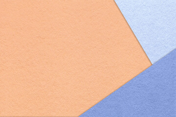 Fototapeta premium Texture of craft coral color paper background with blue and very peri border. Vintage abstract peach cardboard.