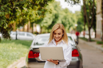 Business woman working on laptop computer outside in city park