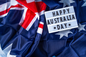 Fototapeta na wymiar Australia Day greeting card Background with australian flag, silver stars, lightbox with text Happy Australia day, paper red, blue, white decor, over blue background copy space